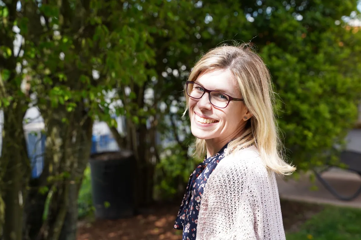 Fotografin Hülya Hieronymus lächelt im Garten in die Kamera